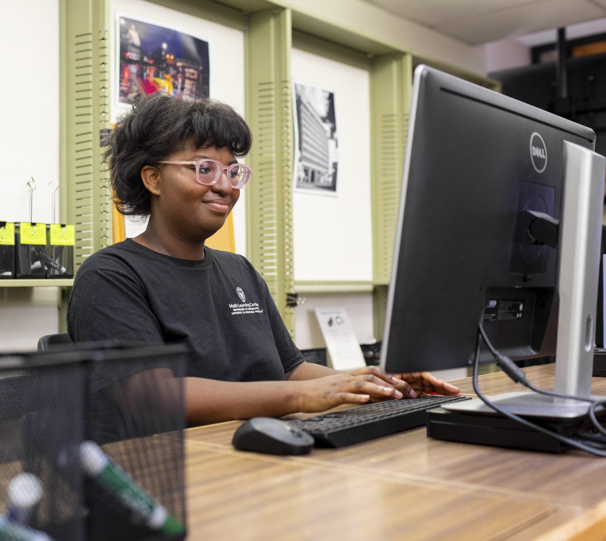 A Front Desk employee works on her computer at the MLC.