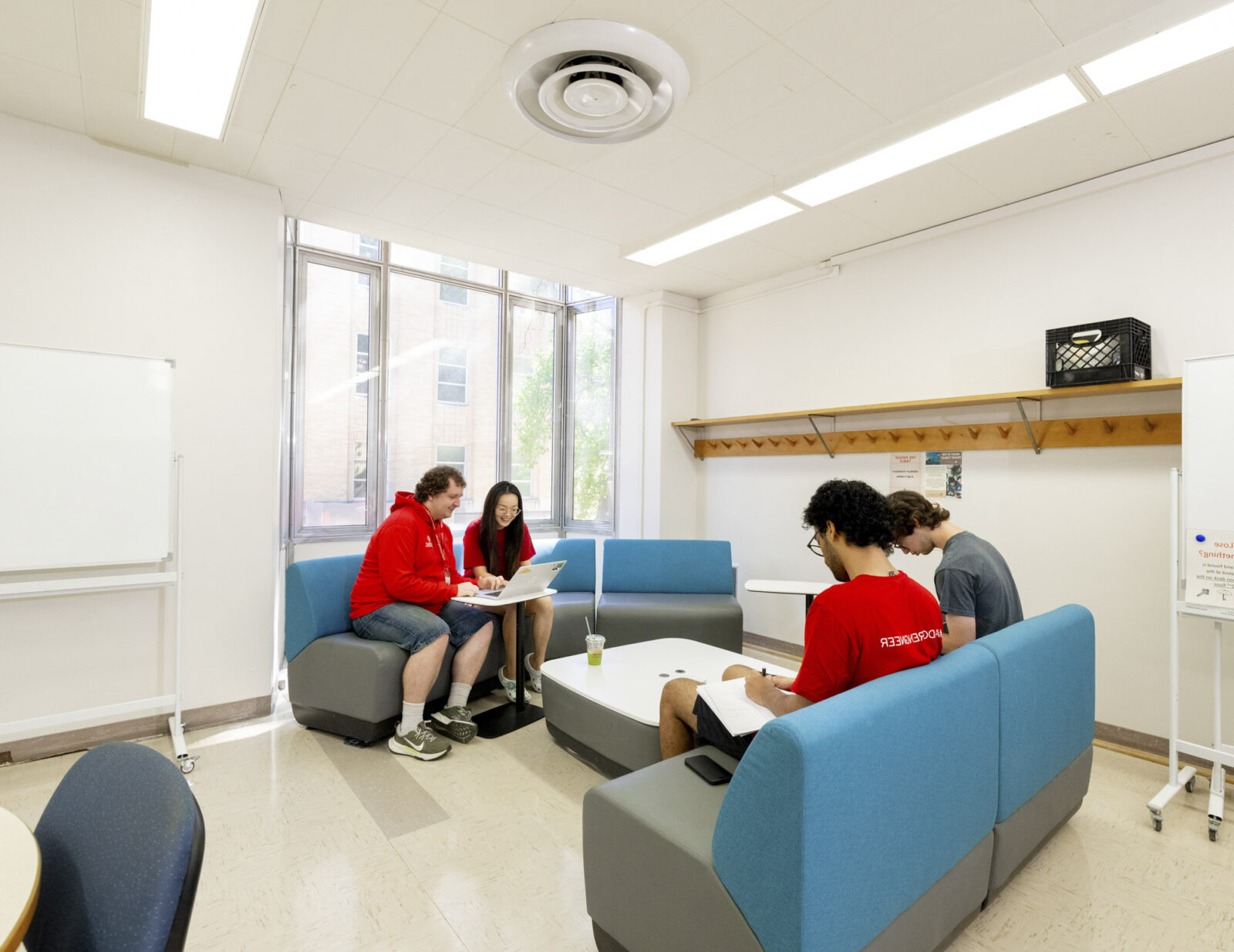 Four students sitting on couches study for exams together.